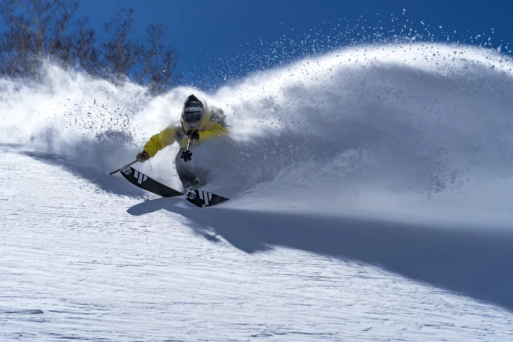 Skier carving through Hakuba powder snow — exceptional Japow quality